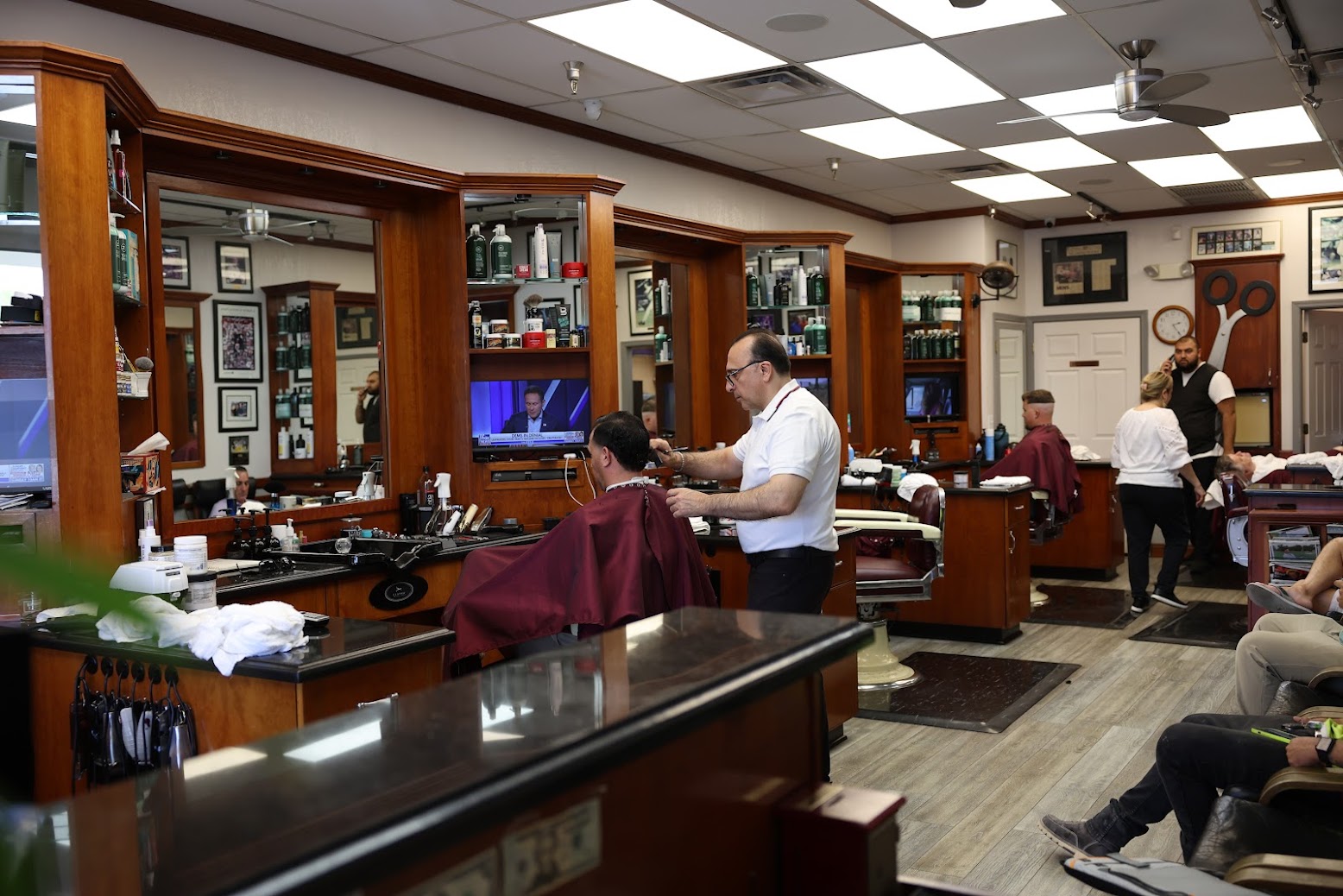 The floor at Classic Barbershop — walnut stations, warm light